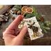 A natural gift tag with a moose wood-burned onto the bark. Tag has a rustic cord tied to a hole in the top corner. 